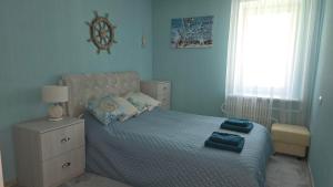 a bedroom with a bed with blue walls and a window at Kristi Apartments in Visaginas