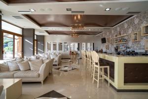ein Wohnzimmer mit Bar und weißen Möbeln in der Unterkunft Evia Hotel & Suites in Marmarion