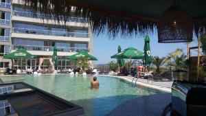 a person in a swimming pool at a hotel at Allure - Lighthouse apartment B35 in Primorsko +3 photos