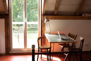 una scrivania con un computer portatile di fronte a una finestra di loft-feeling im Cottage! a Brandenburg an der Havel