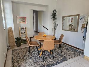 a dining room with a table and chairs on a rug at Marilyn's Cottage in White River