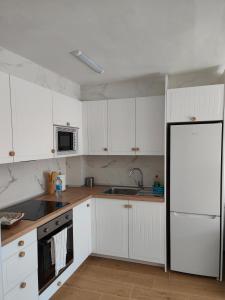 a kitchen with white cabinets and a black refrigerator at Apartamento Ferrandis Benicasim in Benicàssim