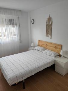 a white bedroom with a bed and a window at Apartamento Ferrandis Benicasim in Benicàssim