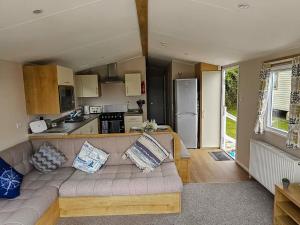 a living room with a couch and a kitchen at Dog Friendly 8 Berth Static Caravan Newquay in Newquay