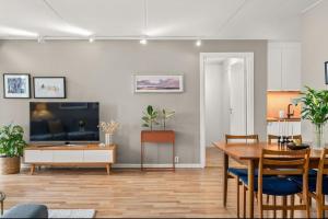 a living room with a dining table and a television at Sentral & Cozy apartment in Oslo