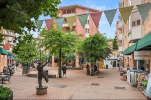 a street with a statue in the middle of a city at Sentral & Cozy apartment in Oslo