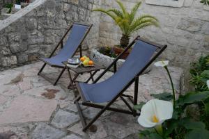 two chairs and a table with fruit on a patio at Lazovic- Apartment by the Sea with Amazing View in Dobrota