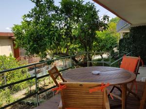 a wooden table and chairs on a balcony with a tree at Lodge Rosa in Agropoli
