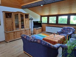 a living room with two chairs and a table and a tv at Ferienwohnung Heckenäcker in Ortenberg