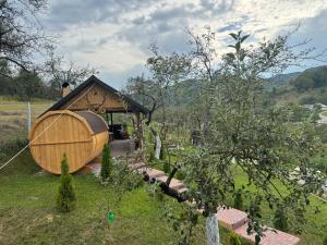 a small building with around house in a field at Rai pe Deal Chalet in Leordina