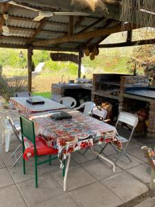 a table and chairs on a patio with a grill at CASA DE CAMPO EN Aculeo in Paine