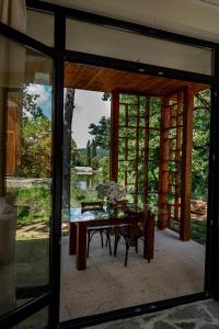 a dining room with a table and a glass door at MAYA- Villas On The Lake in Curchi