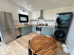 a kitchen with a wooden table and a refrigerator at Reid's Cove Retreat in Tatamagouche