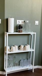 a white shelf with cups and dishes on it at Comfort Apartment - mit 4 Betten in Raubach