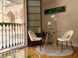 a room with a table and chairs and a window at Puerta al cielo Suite in Burgos