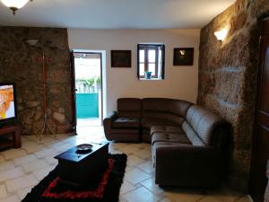 a living room with a couch and a tv at Villa Cantinho dos Avós in Baião