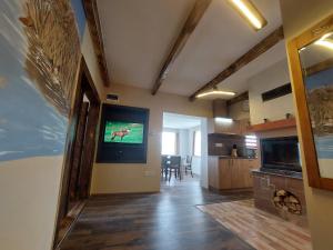 a living room with a tv on the wall at Dámszarvas Vendégház in Újudvar