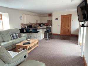 a living room with a couch and a table at Dungavel Cottage in Roberton