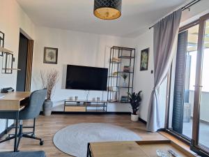 a living room with a flat screen tv and a table at Apartment Mija Rabac with free parking in a garage in Rabac
