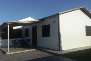 a white house with a large open garage at Casa Alejandra en el palmar in Cádiz