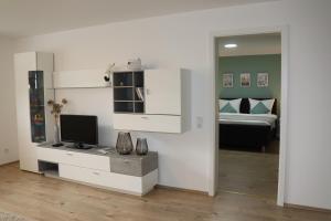 a room with a bed and a desk with a television at Eifelherz mit Sonnenterrasse in Nideggen