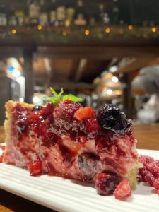a piece of cake with fruit on a white plate at Apartamentos PREMIUM CON YACUZZI DUNAS DEL ESTE in Punta Colorada