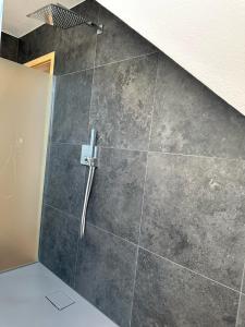 a shower in a bathroom with a tile wall at Familienurlaub am Meer in Hagenburg +17 photos