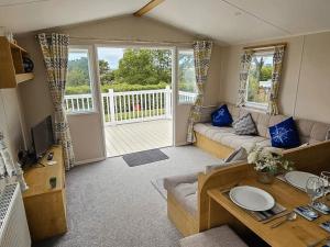 a living room with a couch and a table at Dog Friendly 8 Berth Static Caravan Newquay in Newquay