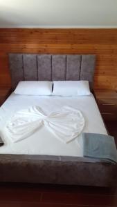 a bed with white sheets and a bow on it at Rrjoll beach House in Baks-Rrjoll