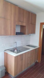 a kitchen with a sink and wooden cabinets at Rrjoll beach House in Baks-Rrjoll