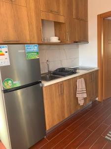 a kitchen with a stainless steel refrigerator and wooden cabinets at Rrjoll beach House in Baks-Rrjoll