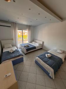 a bedroom with two beds and a window at Samaras Villa in Flogita