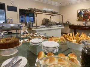 a buffet with plates of food on a table at Hotel Palace in Cachoeiras de Macacu