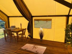 纽波特Usk View Glamping Caerleon的黄色帐篷,配有桌椅 更多5张照片