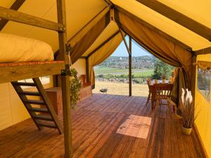 纽波特Usk View Glamping Caerleon的一个带床和桌子的帐篷门廊