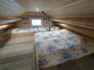 a bedroom with two beds in a log cabin at Pieni Katajaranta in Karvonen