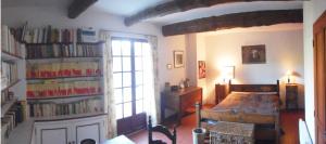 a room with a bed and a book shelf with books at Mas de Regardebon in Mazan