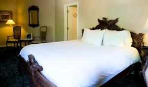 
a bed with white pillows and pillows in a room at The Sanford House Inn & Spa in Arlington
