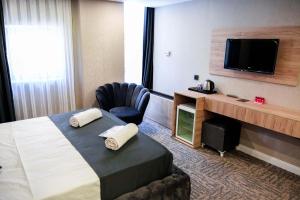 a hotel room with a bed and a chair and a television at Siwiss İnn Experess in Ankara