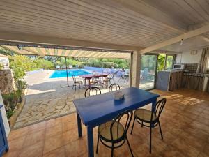 a blue table and chairs on a patio with a pool at La Genestière in Draguignan