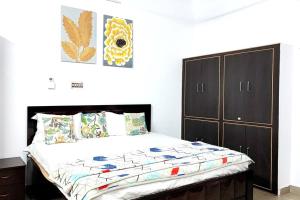 1 dormitorio con 1 cama y armario en Kanha Homestay, en Ayodhya