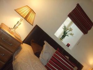 a bedroom with a bed and a lamp and a window at Links Lodge in Lossiemouth