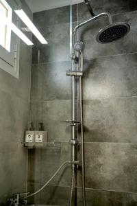a shower with a shower head in a bathroom at Eva's paradise Syros in Ermoupoli +15 photos