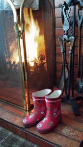 a pair of pink boots next to a fireplace at Links Lodge in Lossiemouth