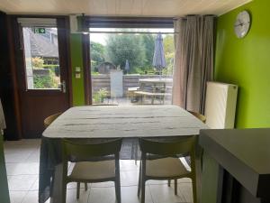 a dining room with a table and chairs and a window at 't Hoppecruyt Logies in Proven