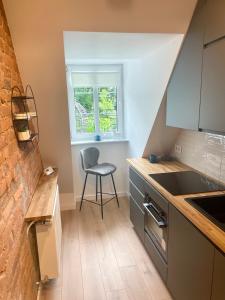 a kitchen with a chair and a sink and a window at Szmaragdowa Sowa in Wałbrzych +19 photos