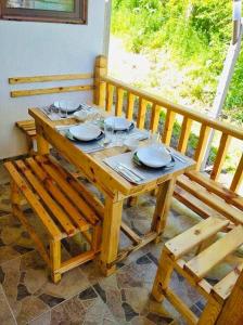 a wooden table with plates and glasses on it at Вила ЕВА in Sinemorets