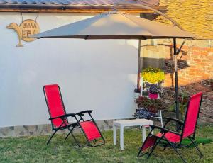 two chairs and a table under an umbrella at Вила ЕВА in Sinemorets