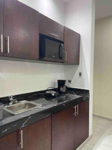 une cuisine avec un évier et un micro-ondes dans l'établissement Departamento amueblado en Altabrisa, à Mérida 7 autres photos