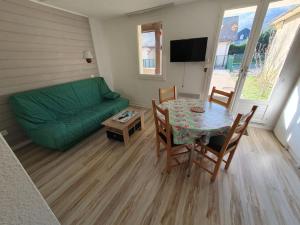 a living room with a table and a green couch at Arriu 35 in Bielle